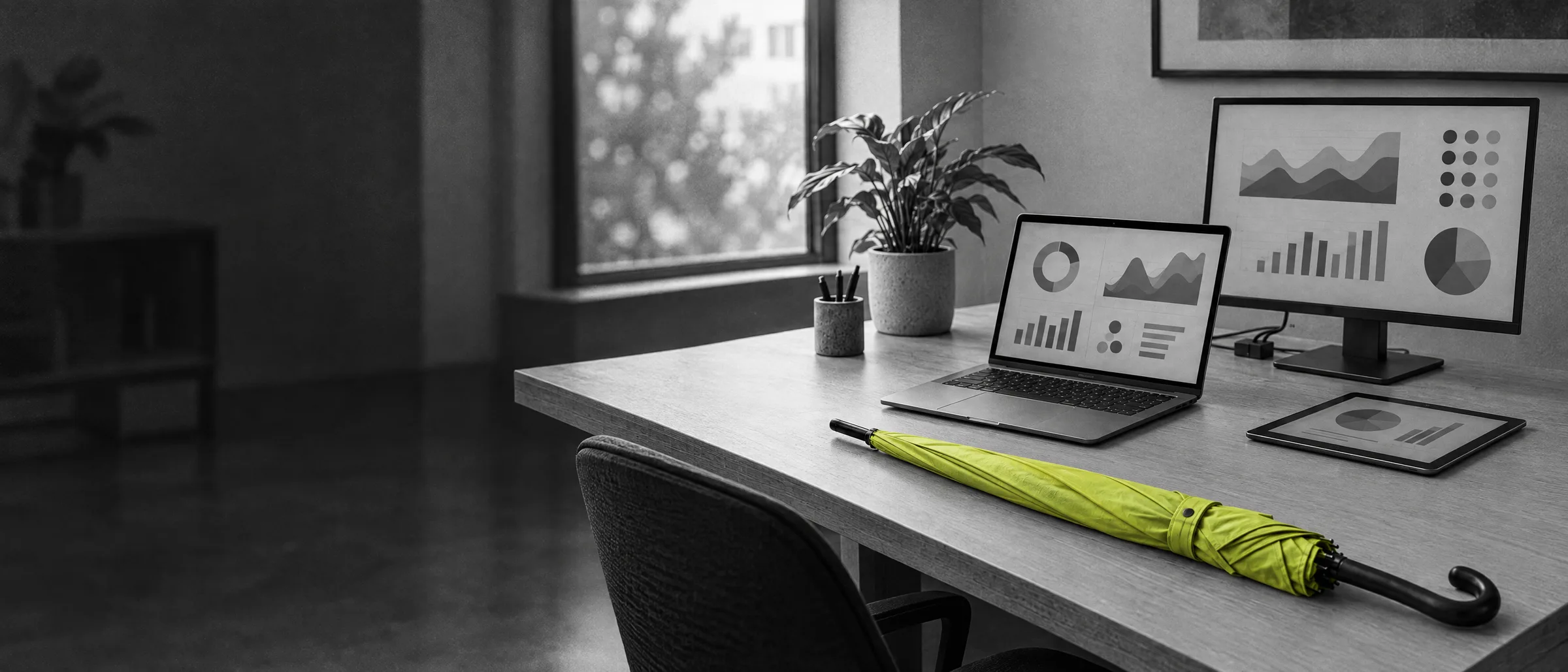 Opgeruimd bureau met laptop en tweede scherm, een lime paraplu op de hoek